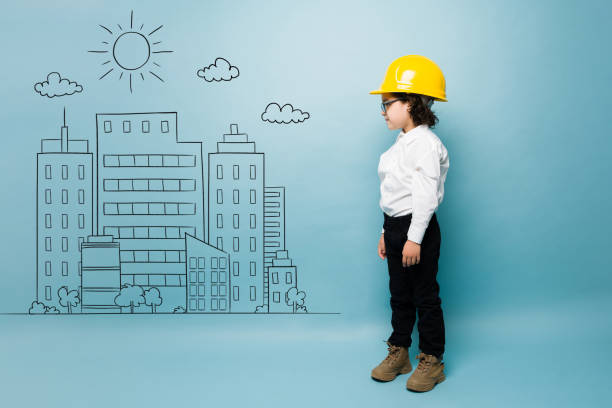 istock Caucasian boy playing architect with a yellow helmet 1412583428