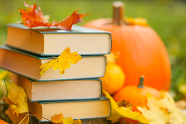 istock Study and education concept.Autumn books.back to school. Halloween books. Autumn reading.Stack of books,pumpkins on the autumn garden background 1412583468