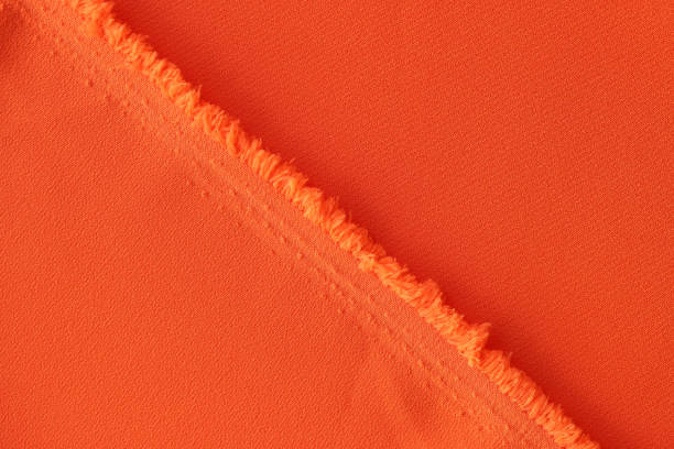 tejido naranja y textura de hilos de tela naranja brillante con pliegues - rayon fotografías e imágenes de stock