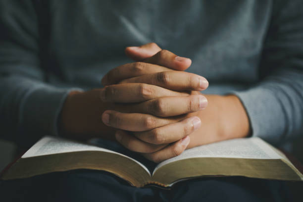 기도하는 사람이 성경에 손을 꼭 붙였습니다. 그리스도인의 삶의 위기를 하나님께 드리는 기도. 사람 더 나은 삶을 바라는 하나님의 축복을 위해 기도하십시오.  선을 믿으십시오. 영성과 종교.� - kneeling praying women begging 뉴스 사진 이미지