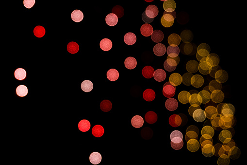 Out of focus bokeh balls of colorful led light with dark background during Diwali festival in India.