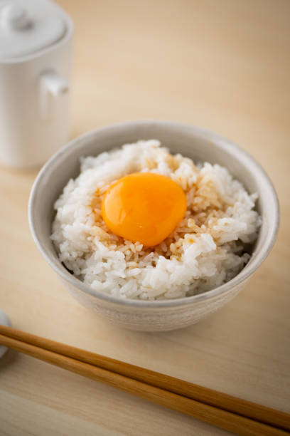 istock Tamagokake gohan, raw egg yolk on white rice, japanese breakfast 1412593311