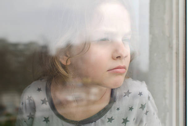 istock The child looks out the window 1412594390