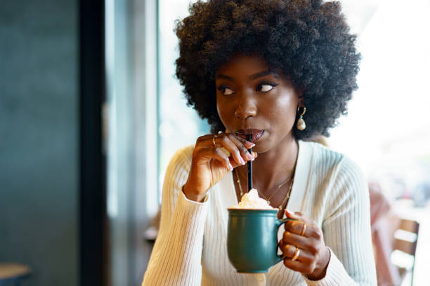 istock Young afro woman taking break and drinking coffee in cafe 1412601917