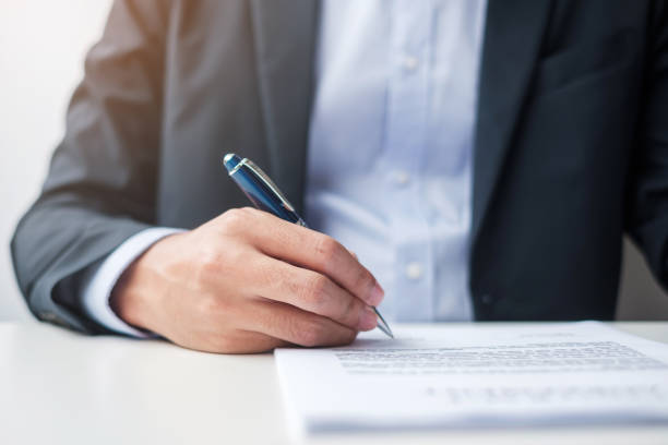 istock man signing on contract documents after reading, man holding pen and approve on business report. Contract agreement, law and deal concepts 1412602991