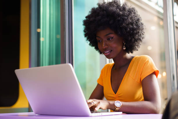 istock Happy beautiful young black woman using laptop in cafe 1412603011