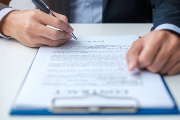 istock Businessman signing on contract documents after reading, man holding pen and approve on business report. Contract agreement, partnership and deal concepts 1412603056