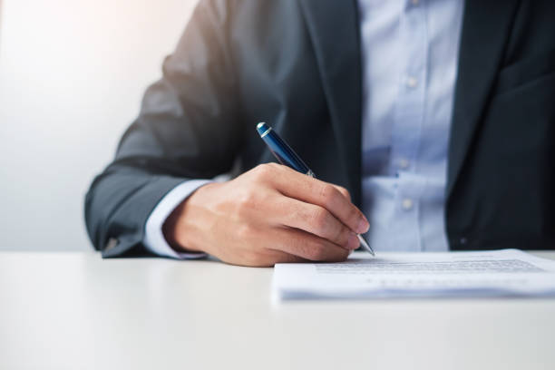 istock man signing on contract documents after reading, man holding pen and approve on business report. Contract agreement, law and deal concepts 1412603059