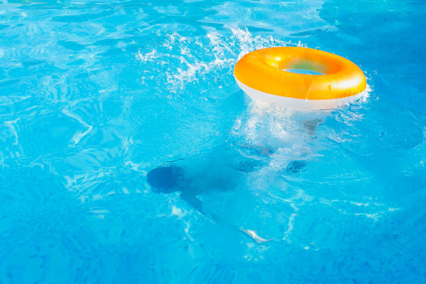 istock White 9-year-old boy floating on an inflatable life buoy dived deep under the water. 1412604297