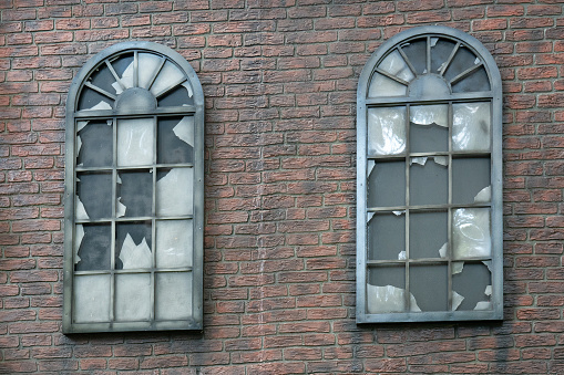 Demolished window with broken glass and stone.