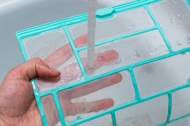 istock Washing the filter from the internal unit of the split system under water pressure. Close up 1412606988