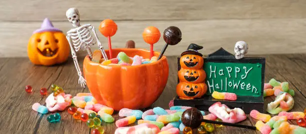 Photo of Happy Halloween day with ghost candies, pumpkin bowl, Jack O lantern and decorative (selective focus). Trick or Threat, Hello October, fall autumn, Festive, party and holiday concept