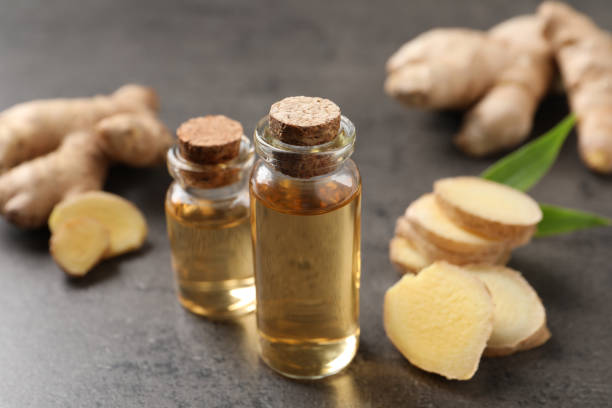 istock Glass bottles of essential oil and ginger root on grey table 1412609429