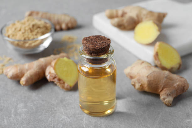 istock Glass bottle of essential oil and ginger root on grey table 1412610537
