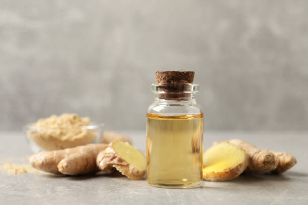 istock Glass bottle of essential oil and ginger root on grey table 1412610549