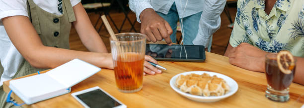 istock Young people looking at the tablet in a coffee shop 1412610821
