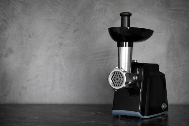 istock Modern electric meat grinder on black table. Space for text 1412618537