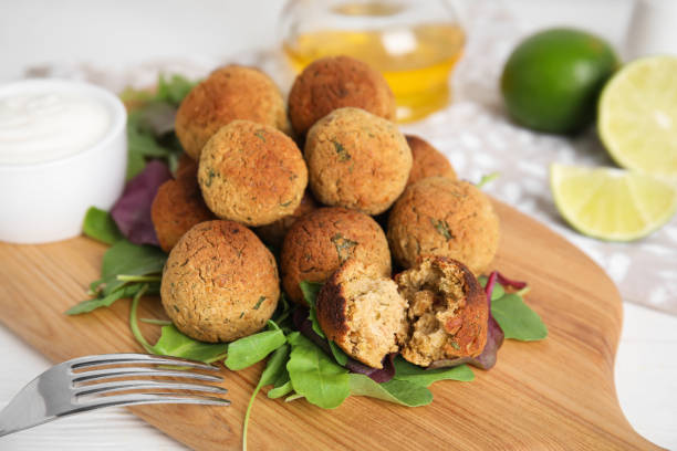 istock Delicious falafel balls with herbs on white table, closeup 1412618922