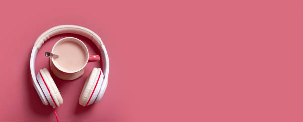 istock Creative flat lay composition with cocoa cup and headphones on dark pink color background. Creative music, relax, online concept. Banner format 1412619155