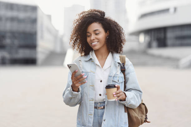 istock Happy woman using smart phone in a city 1412619421