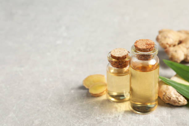istock Ginger essential oil in bottles on light grey marble table. Space for text 1412621551