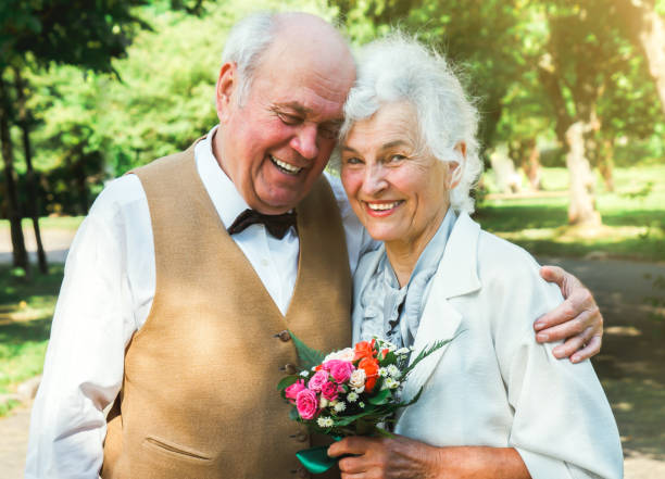 glückliche seniorenpaar-liebesgeschichte. altes paar geht im grünen park spazieren. großmutter und großvater lachen. lebensstil älterer menschen. - senior adult women park bench 70s stock-fotos und bilder