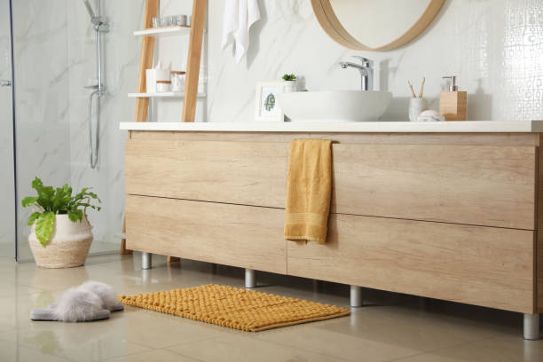 istock Soft orange bath mat and slippers on floor in bathroom 1412622642