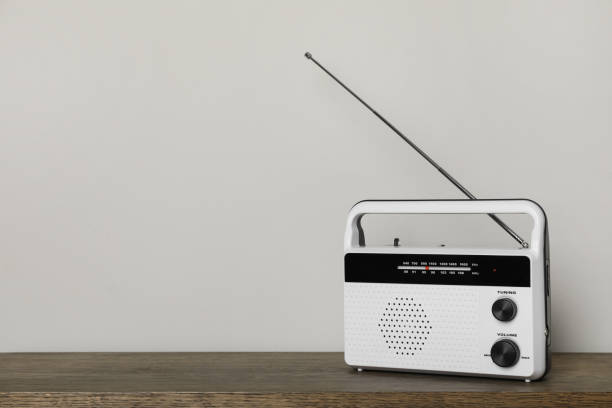 istock Retro radio receiver on wooden table against light grey background. Space for text 1412623601
