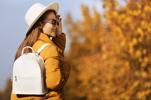 istock Young woman with stylish backpack on autumn day, space for text 1412624874