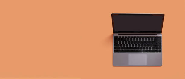 istock Top view of modern laptop isolated on orange background. Copy space 1412625239