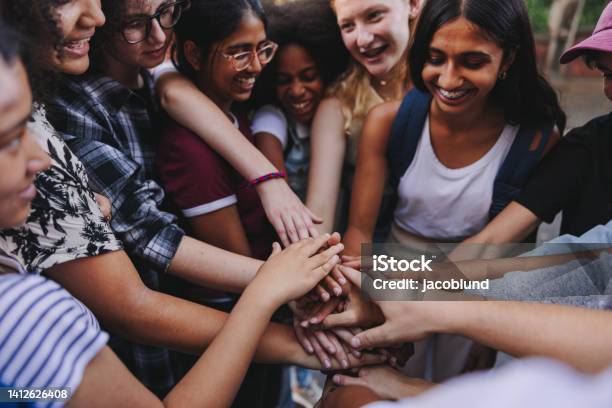 Group Of Multicultural Teenagers Putting Their Hands Together In Unity Stock Photo - Download Image Now