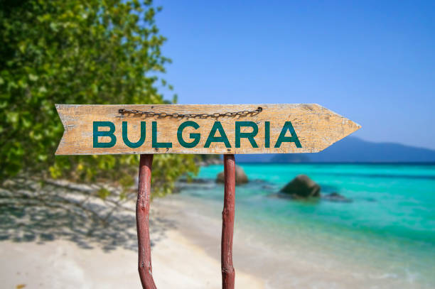 Bulgaria wooden arrow road sign against beach stock photo