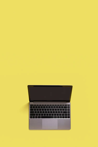 istock Top view of modern laptop isolated on yellow background. Copy space 1412629140