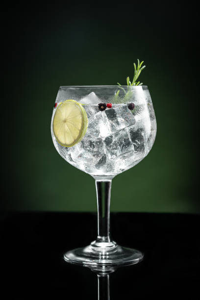istock Cold glass of gin tonic with ice on dark green background with copy space. Vertical format. 1412629234