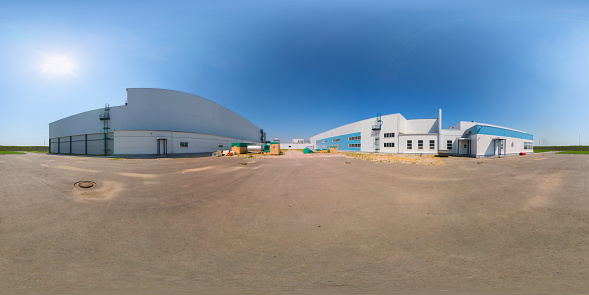 Seamless full spherical 360 degree panorama in equirectangular projection of outdoor industrial area with white buildings aphalt parking at sunny summer day