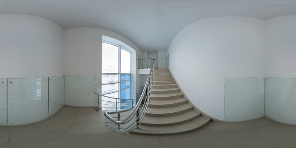Seamless full spherical 360 degree panorama in equirectangular projection of stairway with white walls covered with glass panels in generic industrial or office building