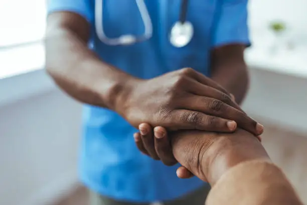 Senior man holding hands with a male nurse.