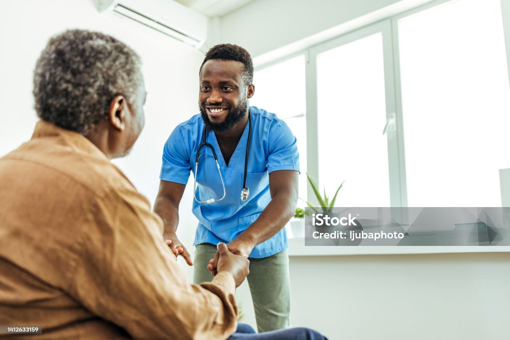 Hands were made to help Shot of a nurse holding a senior man's hands in comfort. Male Nurse Stock Photo