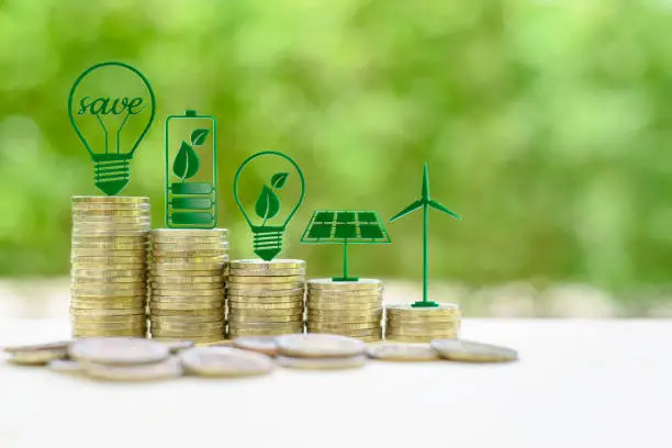 Photo of Alternative or renewable energy financing program, financial concept : Green eco-friendly or sustainable energy symbols atop five coin stacks e.g a light bulb, a rechargeable battery, solar cell panel