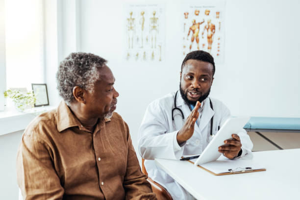 istock Senior man looking at information on digital tablet with doctor 1412634311