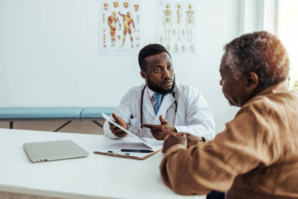 Friendly and Cheerful Family Doctor is Reading Medical History of Senior Male Patient During Consultation Friendly and Cheerful Family Doctor is Reading Medical History of Senior Male Patient During Consultation diabetes consultation stock pictures, royalty-free photos & images