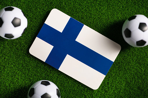 Flag of Finland. Football balls on a green lawn.