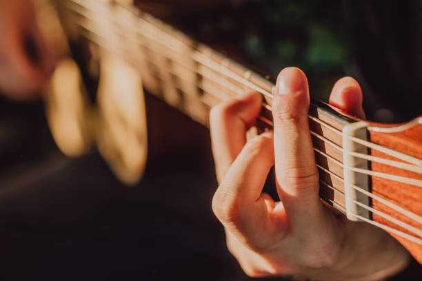 istock Man playing acoustic guitar and playing chords close-up 1412636480
