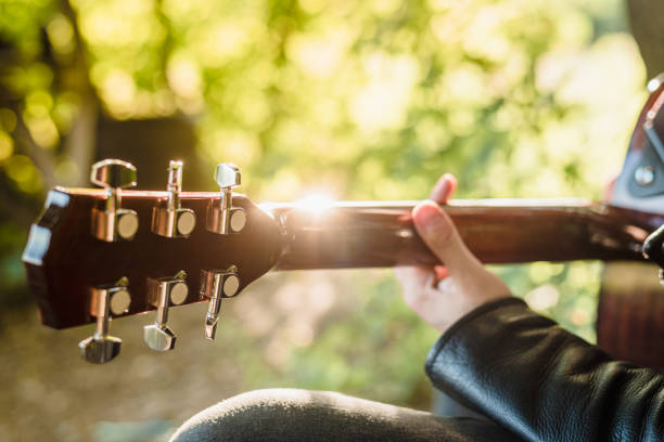 istock Man playing acoustic guitar in nature on a sunny day 1412636498