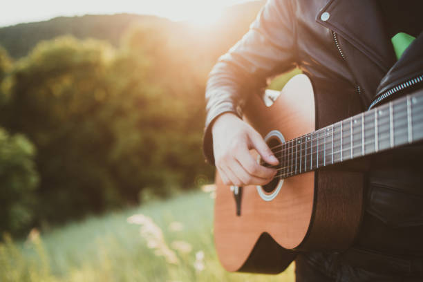 istock Man playing guitar in nature on a sunny day 1412636754