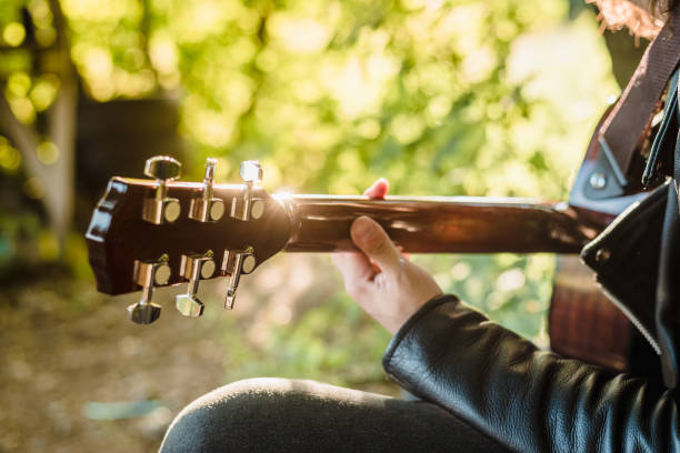 istock Musician man playing guitar at sunset close-up 1412636866