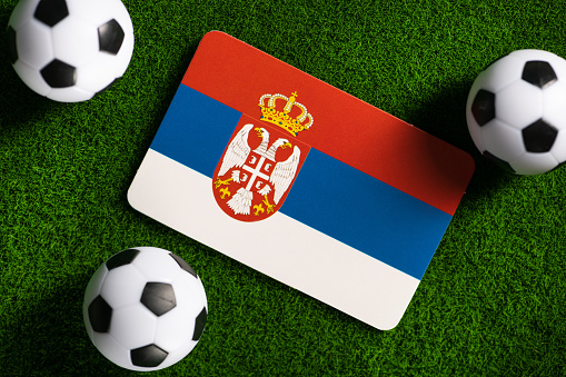 Flag of Serbia. Football balls on a green lawn.