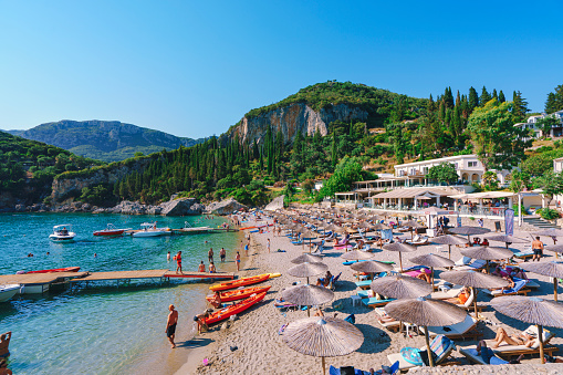 Liapades Beach with relaxing people in Palaiokastritsa Corfu Greece