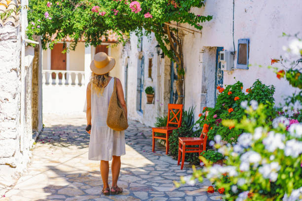 Woman walking in Afionas village with colourful flowers Corfu Greece stock photo