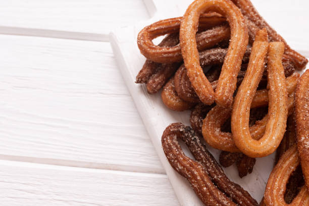 istock Homemade churros on a white wooden background. 1412641228